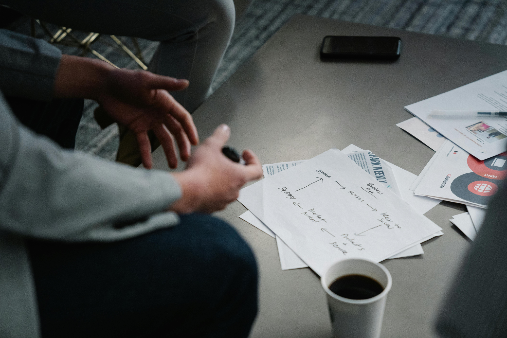 Hands organising documents on a table